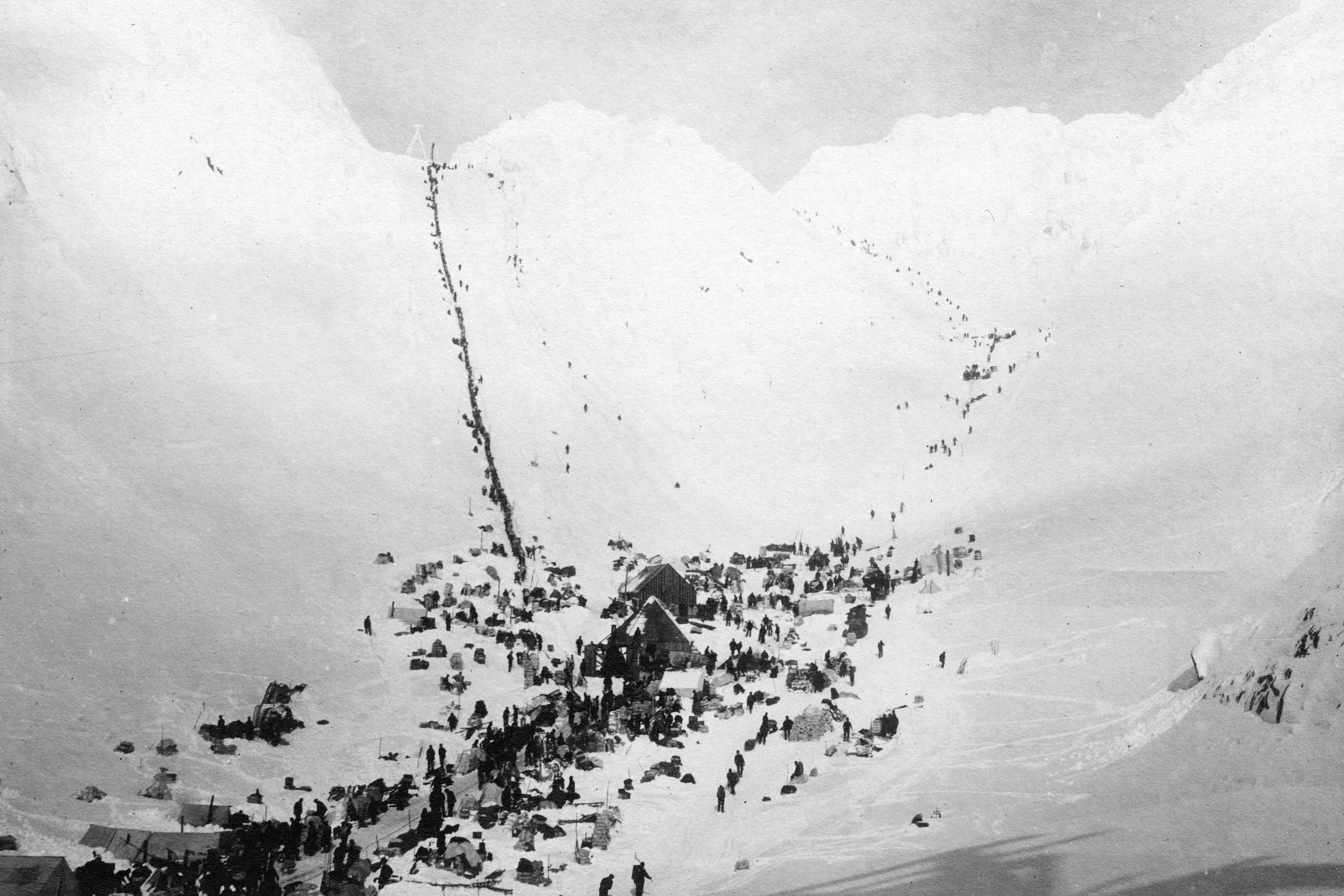 After the discovery of the Bonanza Creek close to Dawson City in 1896, the Chilikoot Trail was one of the first and by that time shortest routes to the Yukon River/Klondike River area. As horses could not climb the so called Golden Stairs (the most streneous part of the trail that you can see in this picture), every man had to carry his own belongings over the Chilikoot Pass. | Photo: Matthews, James Skitt, Major / Copyright: Public Domain / http://searcharchives.vancouver.ca/scales-and-summit-of-chilkoot-pass